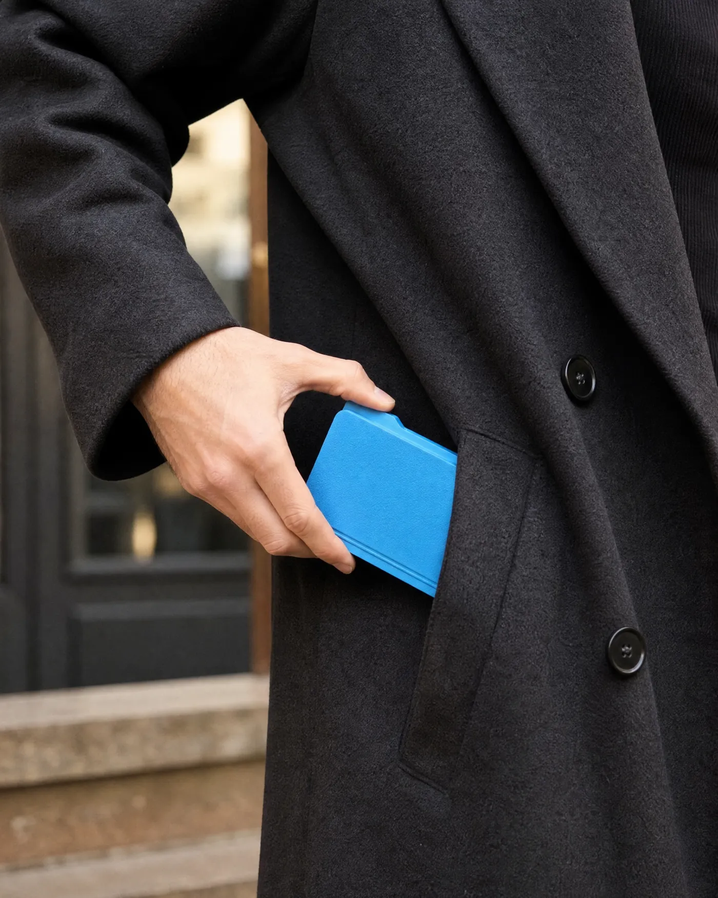 Une main glissant le FOLDISK dans la poche d’un manteau